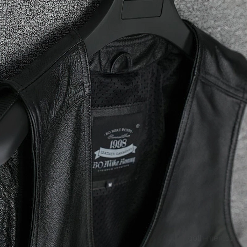 Interior view of gothic collarless leather vest on hanger, displaying polyester mesh lining and brand label placement