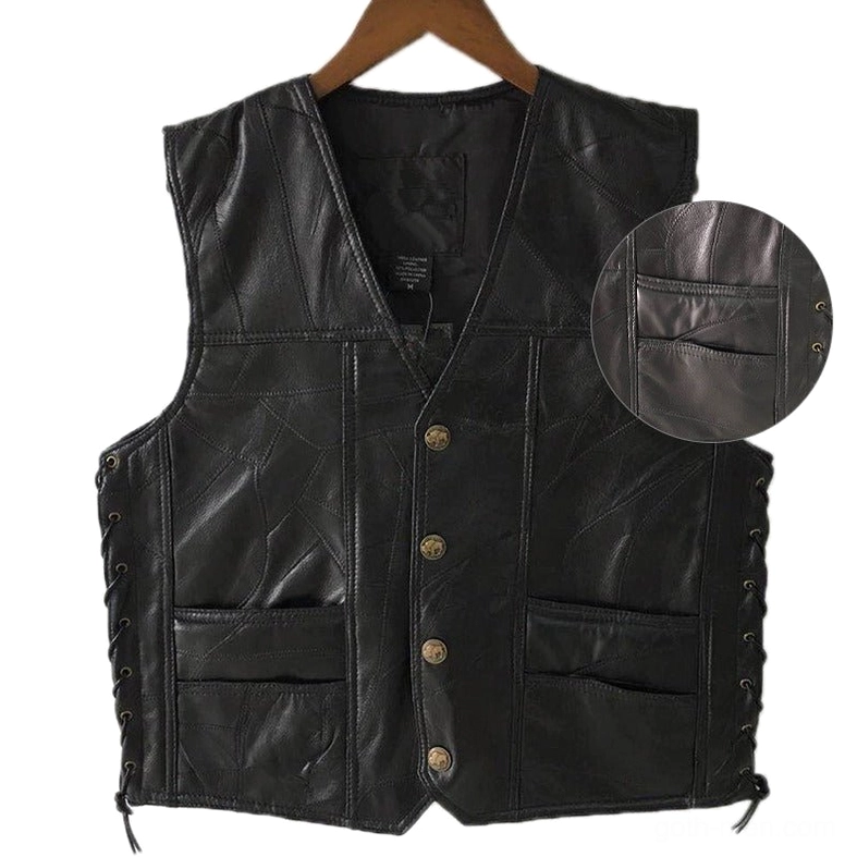 Close-up of embossed golden metal buttons on black gothic leather biker vest