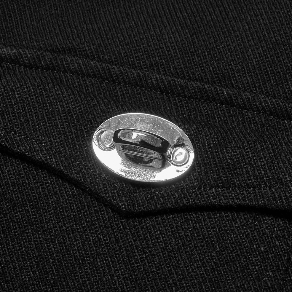 Detailed macro shot of shiny silver oval metal button fastener on black twill fabric of studded gothic vest