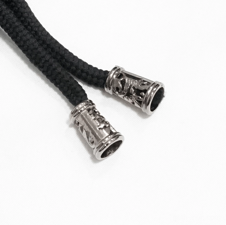 Close-up detail of ornate braided lace cords with metal decorative tips for gothic waistcoat back lacing