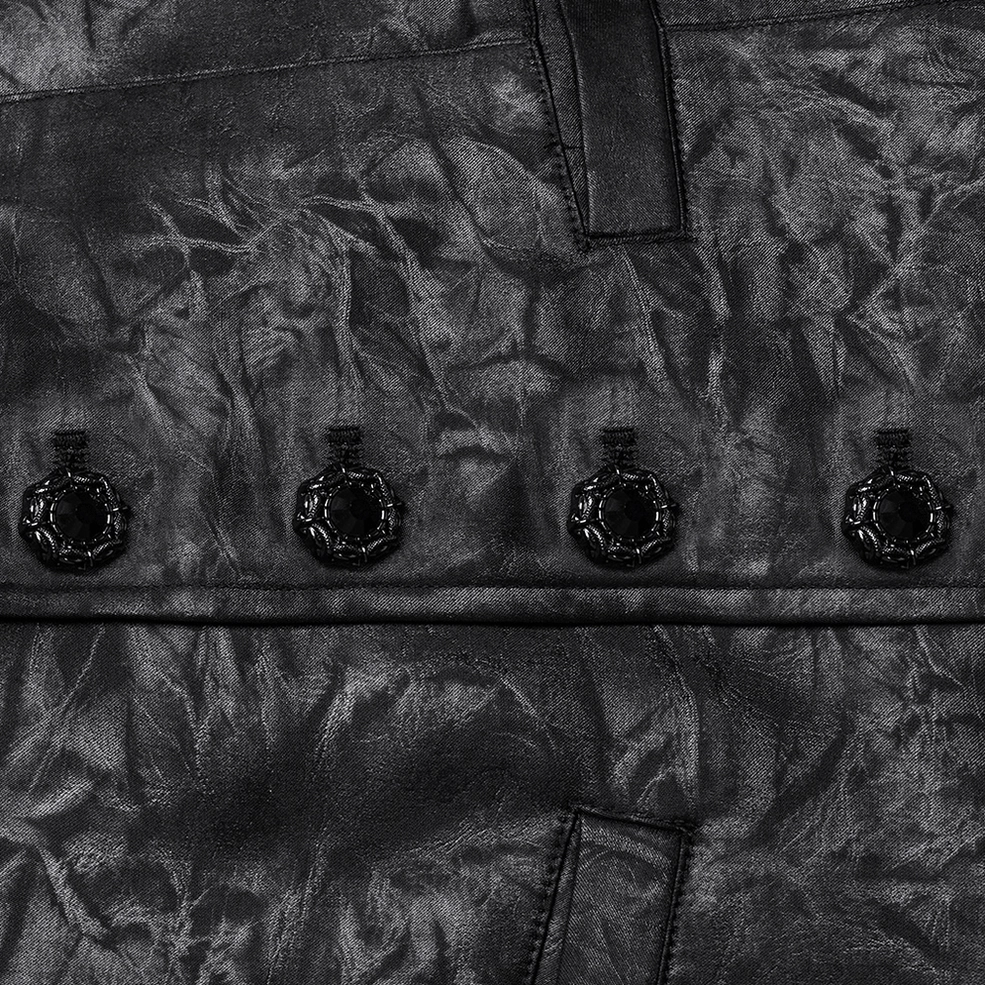 Close-up of carved decorative black buttons on gothic waistcoat with jacquard faux leather fabric texture