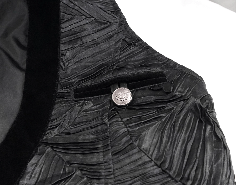 Close-up detail of black gothic waistcoat engraved metal button, velvet trim, and textured crinkled fabric