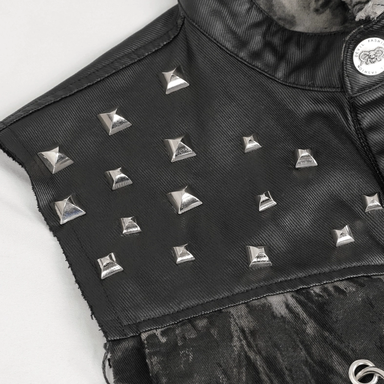 Close-up detail of pyramid metal studs and branded button on black distressed gothic waistcoat