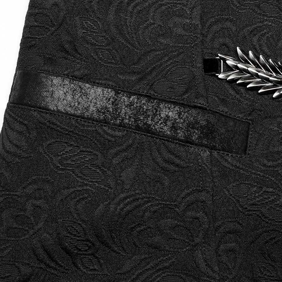 Close-up detail of black gothic waistcoat side ornament showing wing-shaped metal decoration with leather accent and jacquard texture