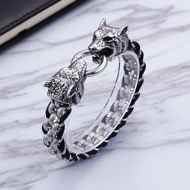 Men's gothic wolf head leather bracelet three-quarter side view with notebook prop displaying chain interlocking pattern