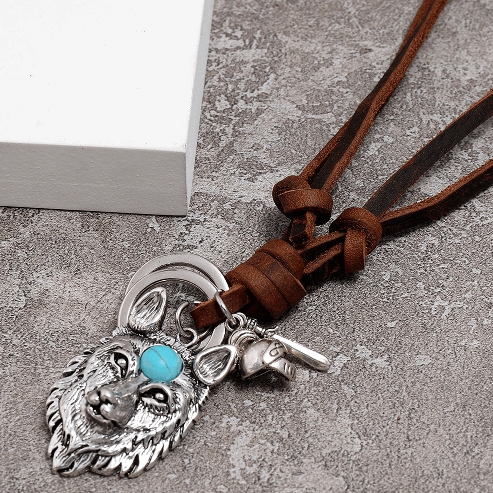 Detailed view of silver wolf head pendant featuring feathered wing accents and turquoise stone
