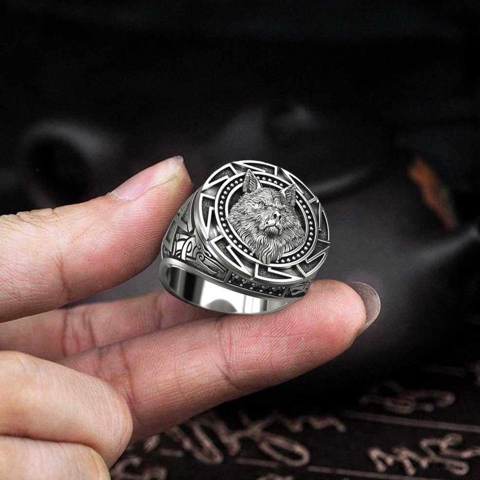 Celtic wolf head ring worn on human finger - embossed wolf centerpiece in dark indoor setting, gothic aesthetic