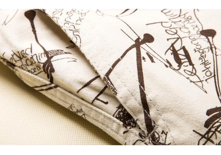 Close-up detail of graffiti printed cotton twill fabric texture on gothic cargo shorts, folded material perspective