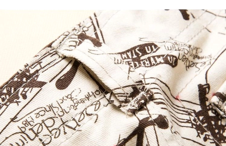 Graffiti text and graphic print detail on cargo pocket stitching, close-up artwork view
