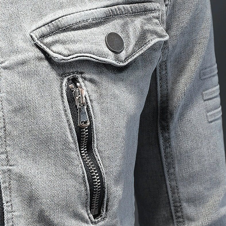 Denim jacket pocket detail showing snap button flap and concealed metal zipper closure