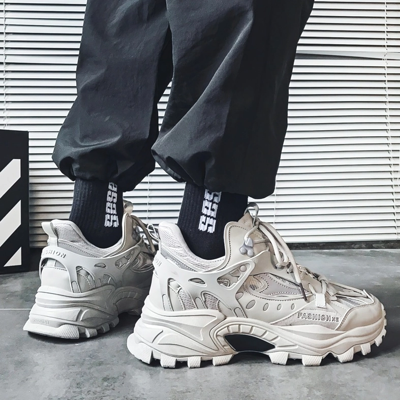 Light gray gothic platform chunky sneakers on model with black track pants and printed socks, rear-side worn view
