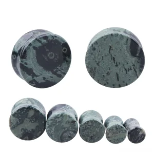 Single large green eye stone flesh tunnel showing dark green color with black mineral inclusions and smooth cylindrical design