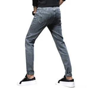Men's smoky grey gothic jeans from rear oblique angle, highlighting back pocket design and stonewashed texture