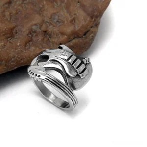 Gothic guitar ring left side angle view showing pickup details and antique silver patina finish on brown rock background