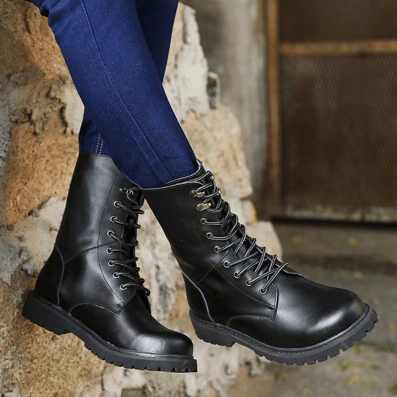 Black mid-calf combat boots detail shot, highlighting handmade split leather construction and precise lace-up cross-tie closure