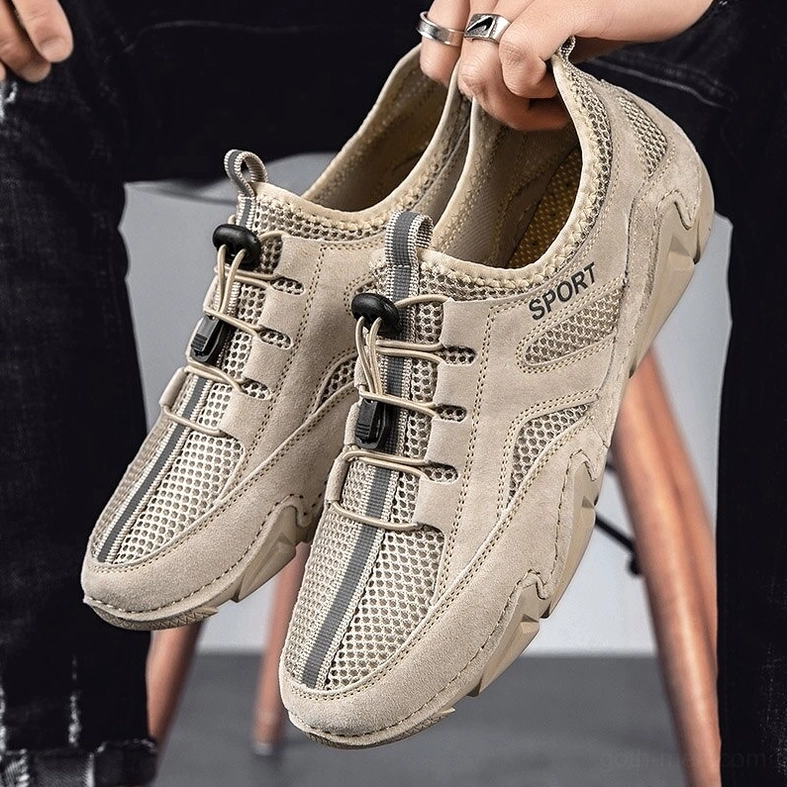 Khaki goth alternative sneaker pair held in hands with indoor studio backdrop