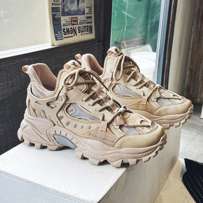 Khaki gothic chunky sneakers pair with gray reflective accents and thick lug sole, shop window display front view
