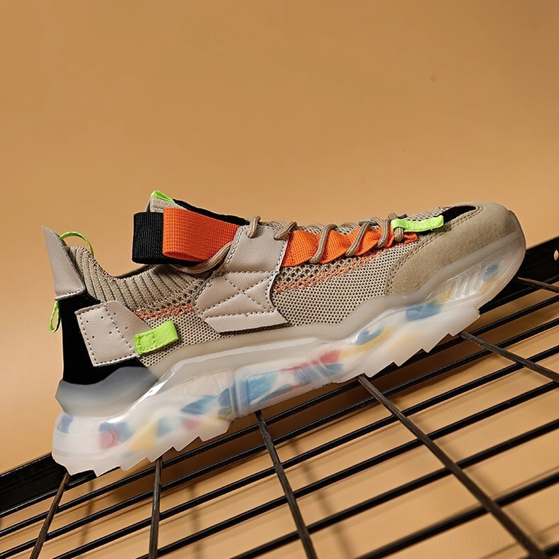 Single khaki gothic platform sneaker with orange accent straps on display stand low angle view
