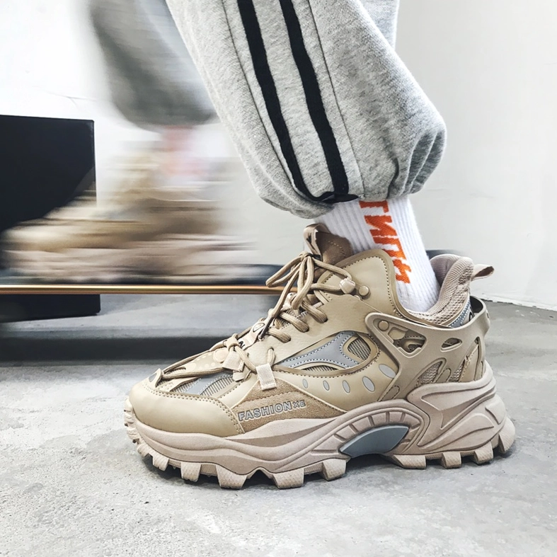 Khaki gothic sneakers styled on model wearing track pants and printed socks, showing off-foot styling with thick lug sole
