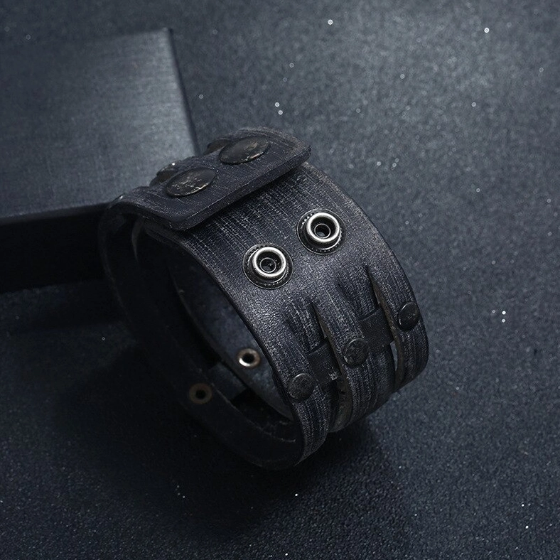 Side close-up detail of black leather gothic cuff bracelet highlighting metal eyelets rivets and distressed leather texture