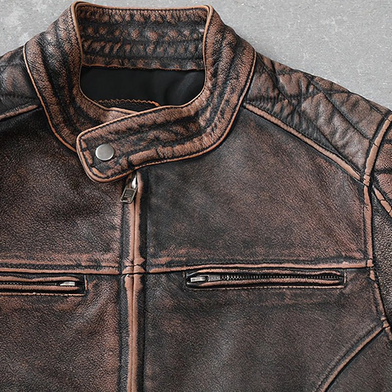 Close-up detail of brown leather jacket front collar area with exposed metal zipper and distressed texture