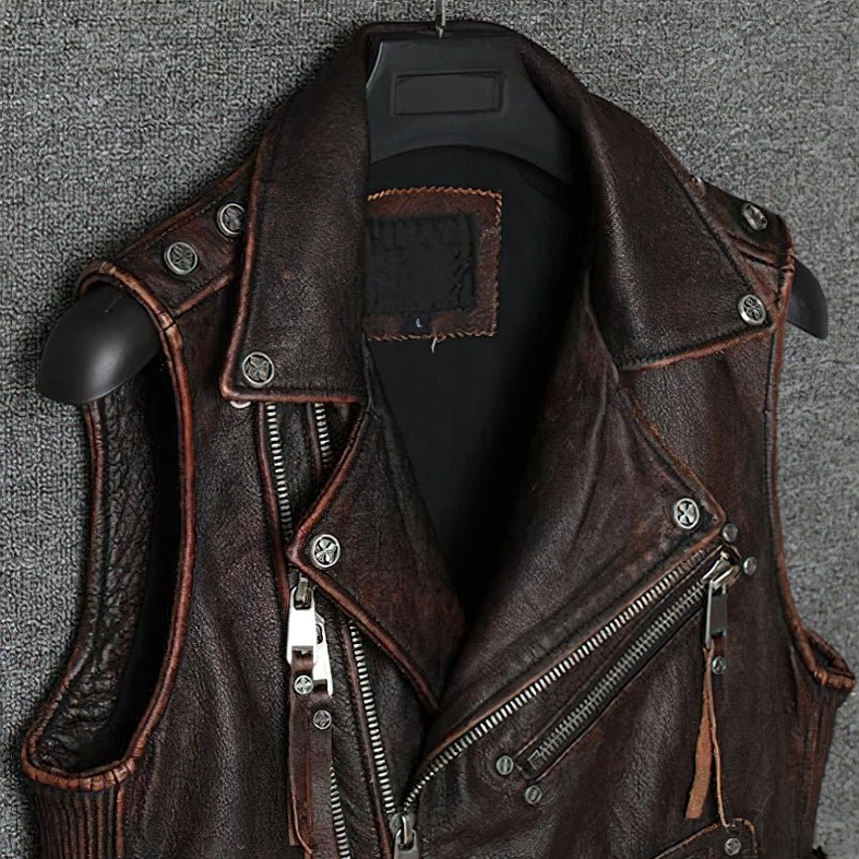 Close-up detail of dual asymmetric zippers on brown leather gothic biker vest metal hardware