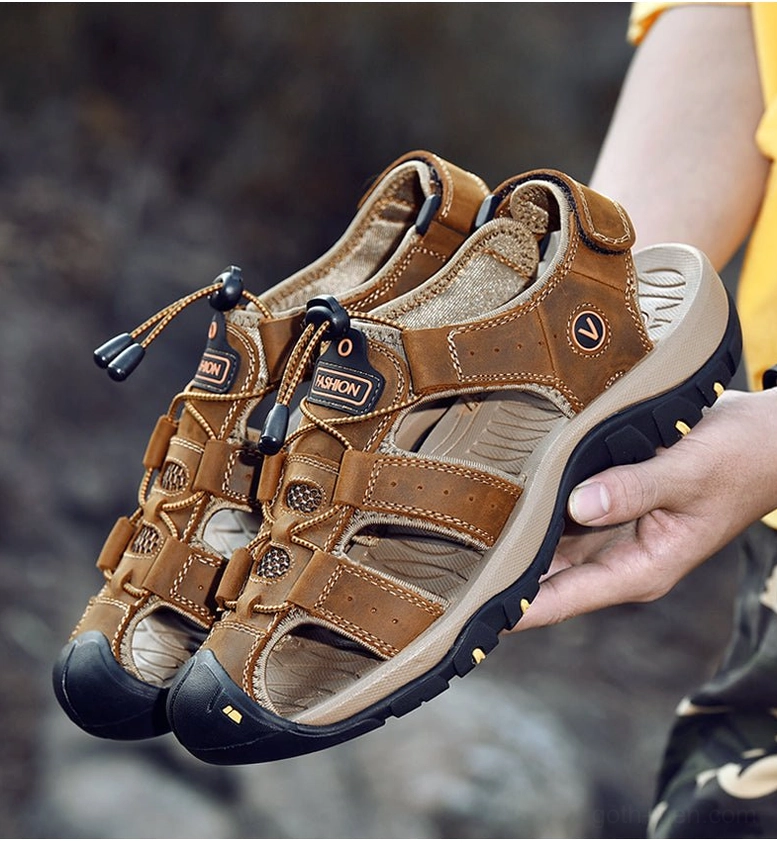 Light brown men's leather gothic sandals with anti-slip rubber outsole and buckle design - side view with hand positioning