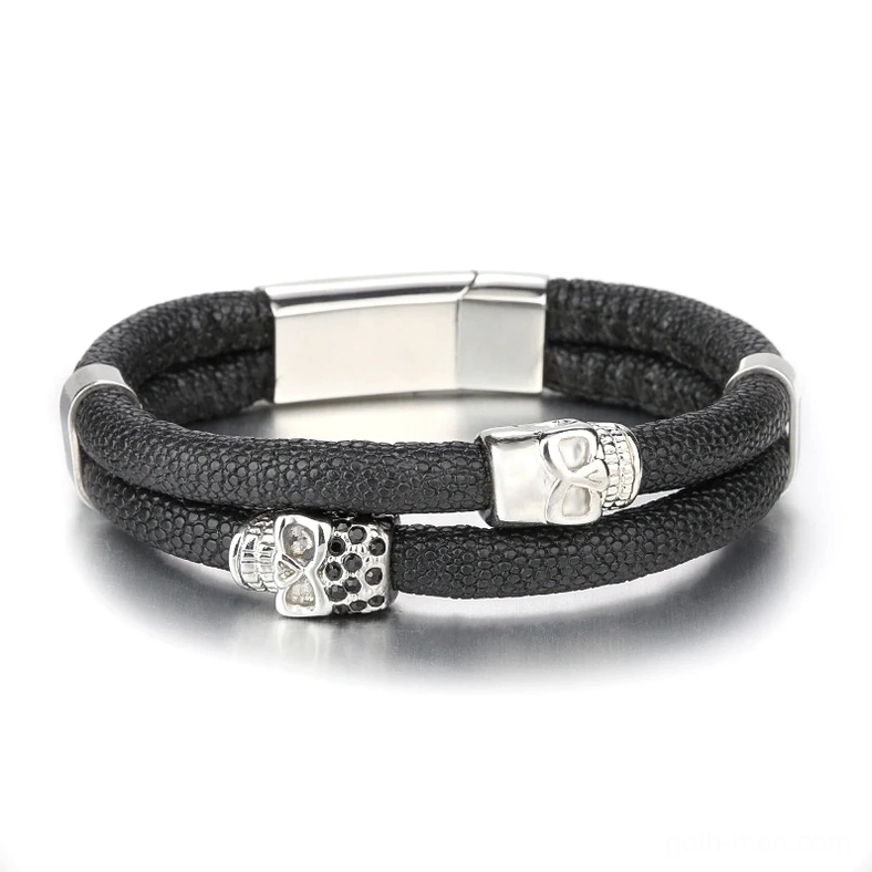 Front view of men's gothic skull bracelet with silver-tone magnetic clasp, two skull decorations, and black leather construction
