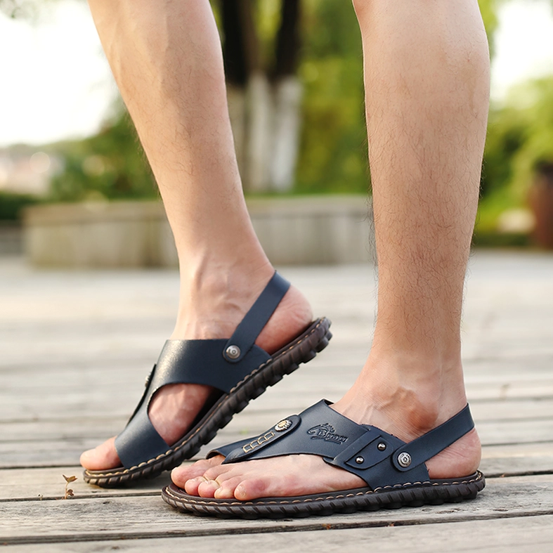 Male model wearing dual navy blue leather gothic sandals ankle-wrap design outdoor wooden deck