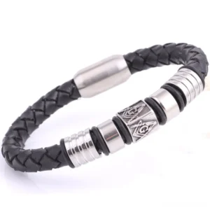Side angle view of stainless steel magnetic leather bangle with Masonic engravings and layered metal rings against black leather band