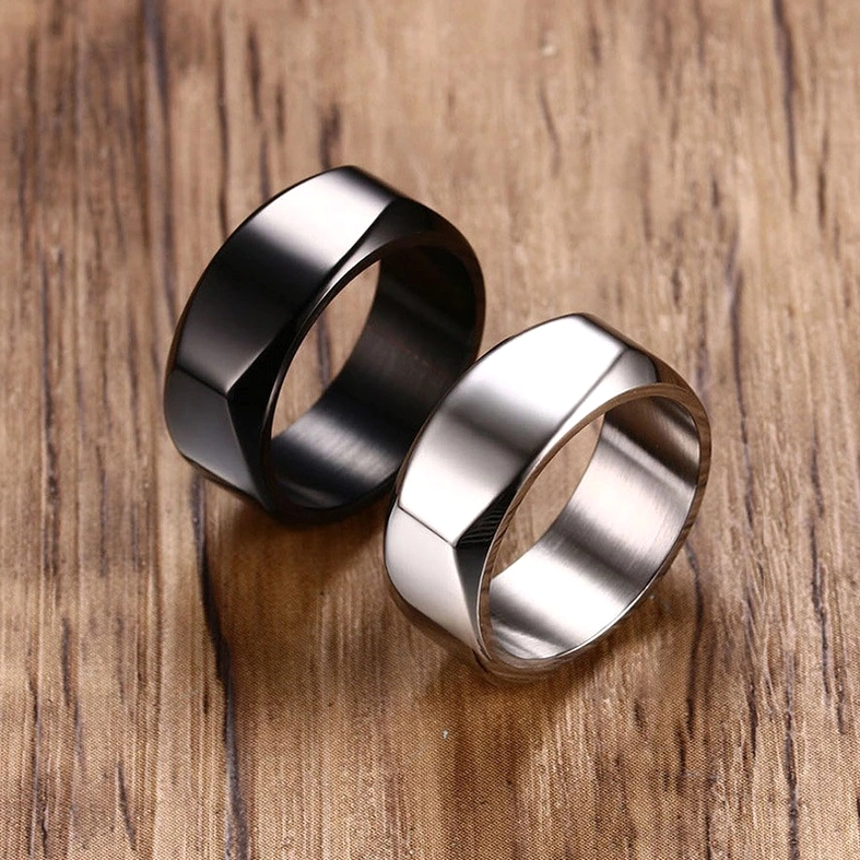 Matching pair of geometric gothic rings in black and silver stainless steel with identical beveled design, duo flat lay