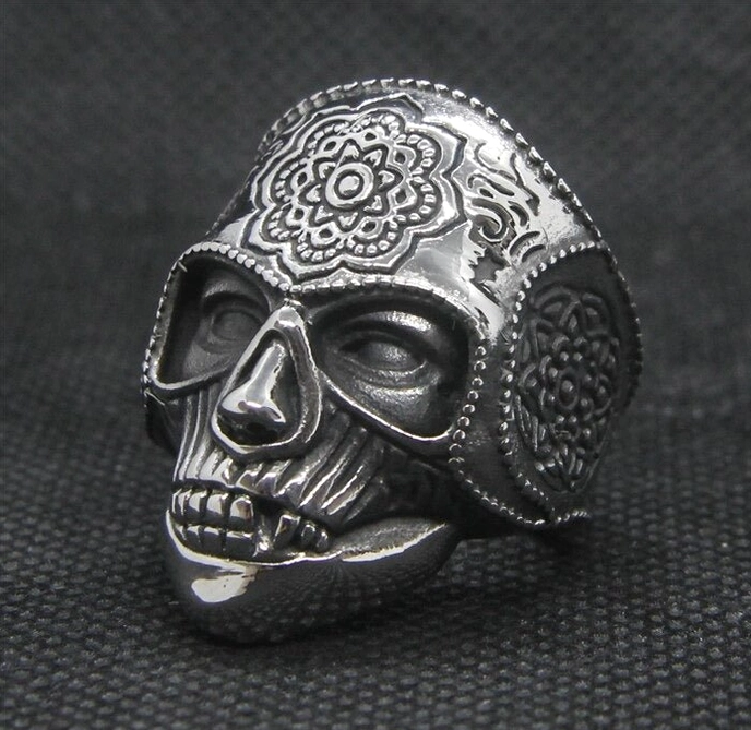 Silver mandala sugar skull ring with matte finish and precise skull detailing against dark fabric background studio shot