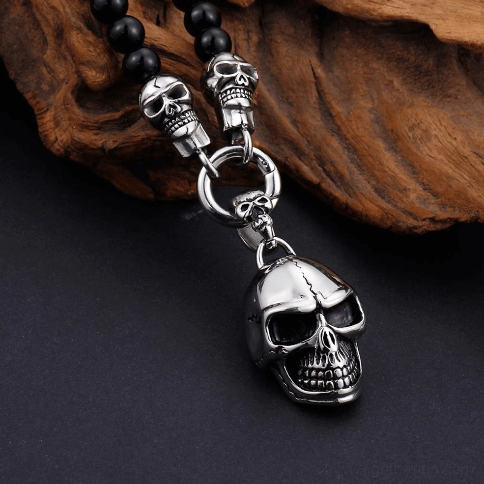 Carved detailed skull pendant memento mori gothic necklace oblique angle driftwood background