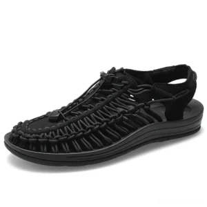 Black leather gothic ankle-wrap sandals for men with elastic toggle closure, three-quarter front view