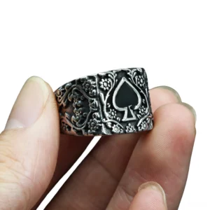 Vintage gothic spade ring on male fingers, close-up side view showing embossed floral carvings and black spade emblem