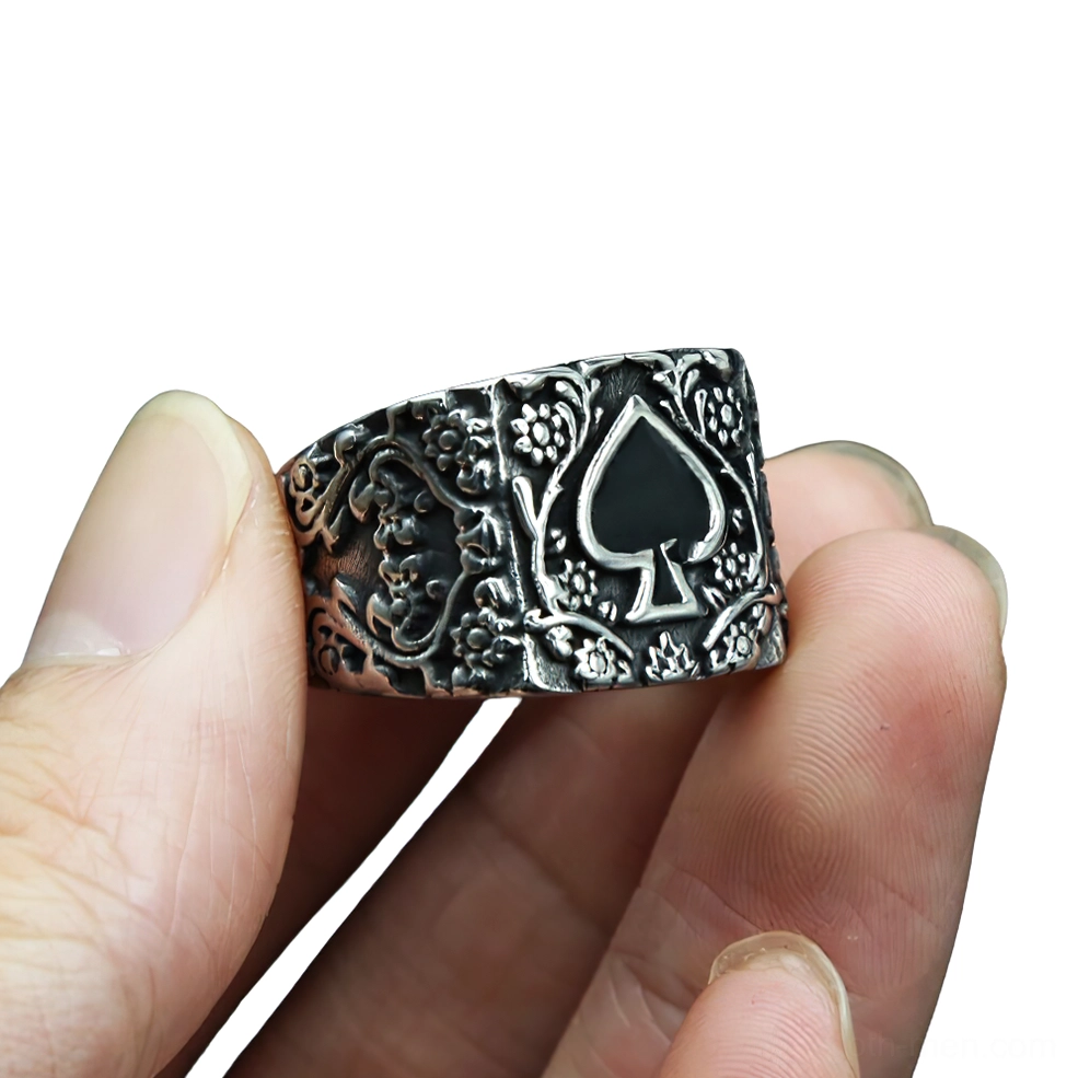 Vintage gothic spade ring on male fingers, close-up side view showing embossed floral carvings and black spade emblem