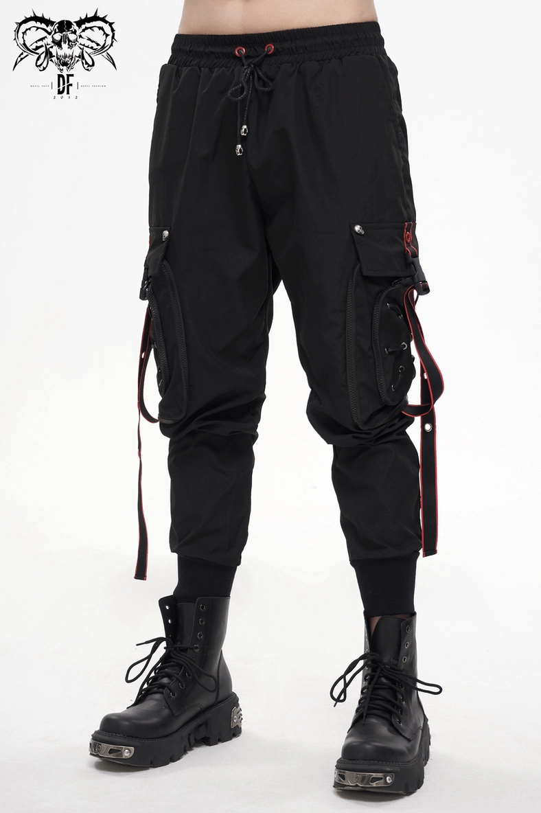 Full length view of men's black gothic cargo pants highlighting red accent straps and silhouette