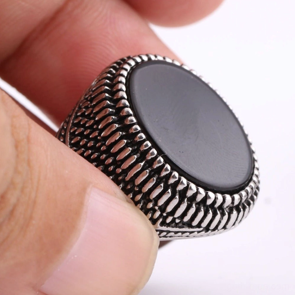 Men's black stone signet ring on hand close-up side view silver black dual tone
