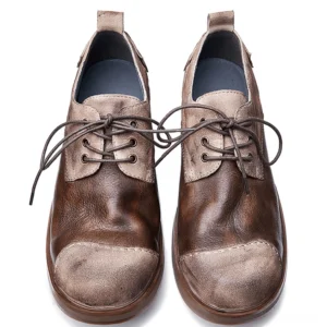 Pair of men's dark leather gothic boots flat lay from above, showing distressed texture, blue inner lining, and lace-up closure detail
