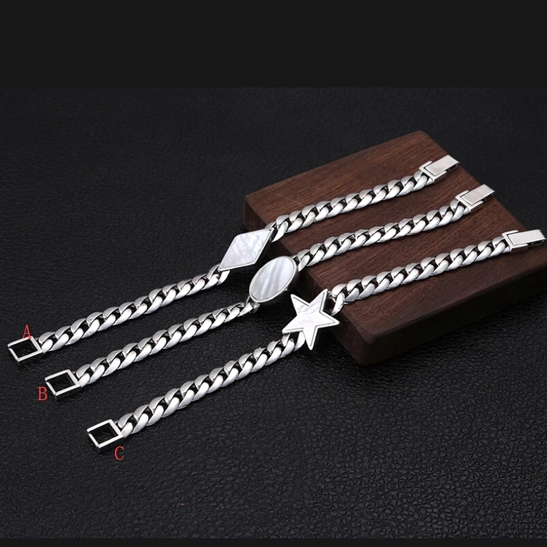 Three-piece men's gothic silver bracelet set featuring star, oval shell, and rhombus charms displayed on wooden stand