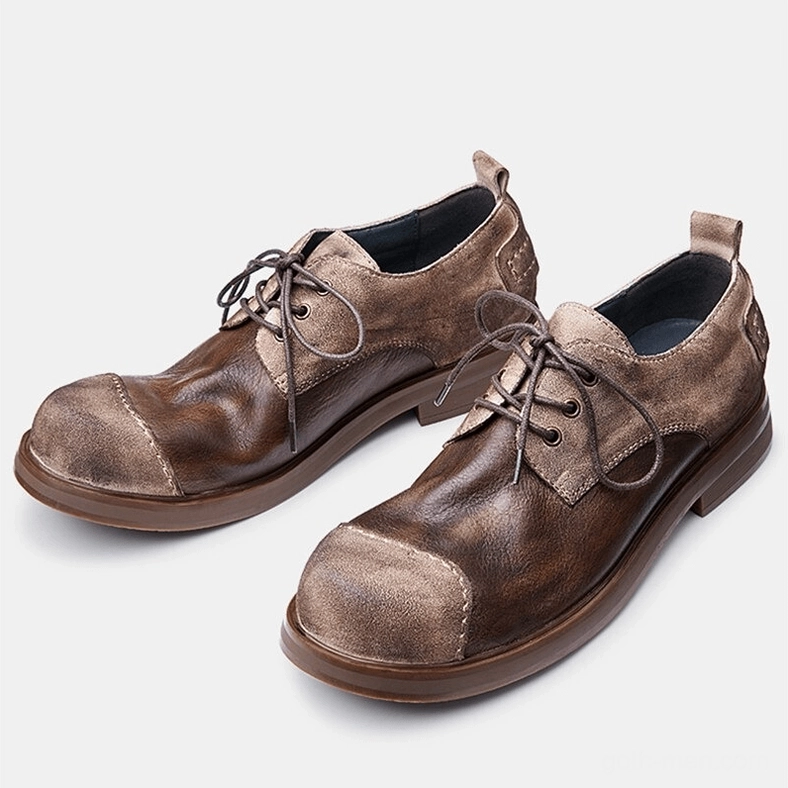 Pair of dark distressed leather lace-up gothic boots three-quarter front view, showing low block heel and round toe design
