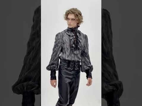 Male model wearing charcoal gothic lace-up shirt with leather waist belt and detailed lace-up cuff styling demonstration