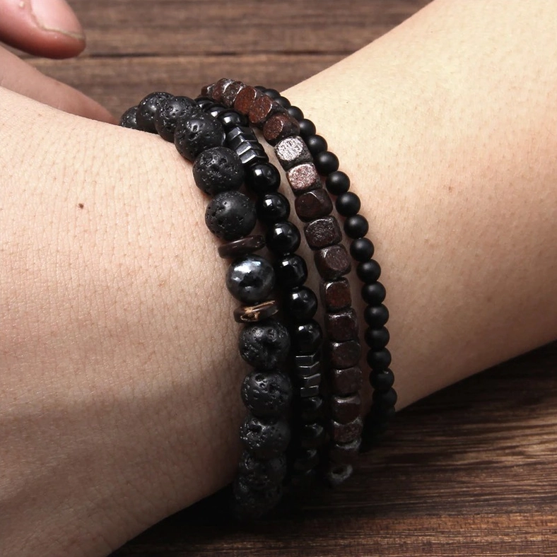 Stone and wood beaded bracelet set worn on real male wrist - close-up side angle showing natural stone bead texture and styling