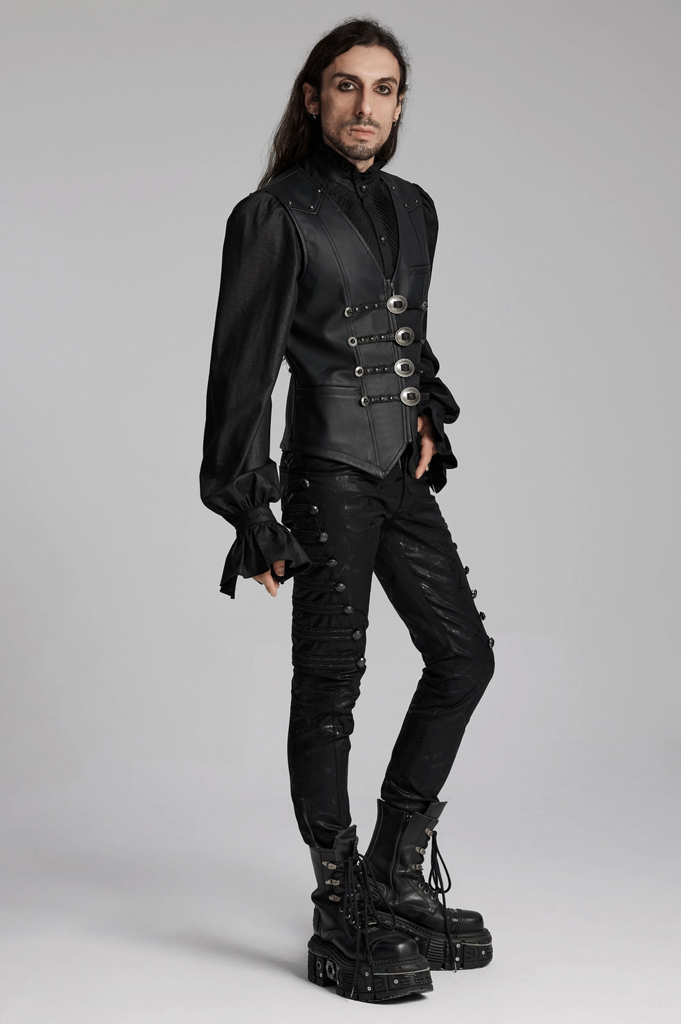 Men's black gothic waistcoat with metal riveted buckles worn by long-haired model in studio setting