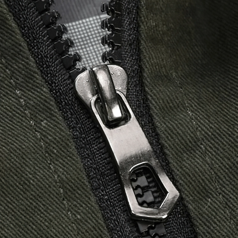 Macro close-up of military bomber jacket heavy-duty metal zipper and cotton twill fabric texture - premium hardware detail