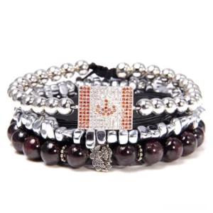 Stacked dark red stone bead bracelet set with rhinestone flag pendant and silver metal floral charm details, layered gothic style