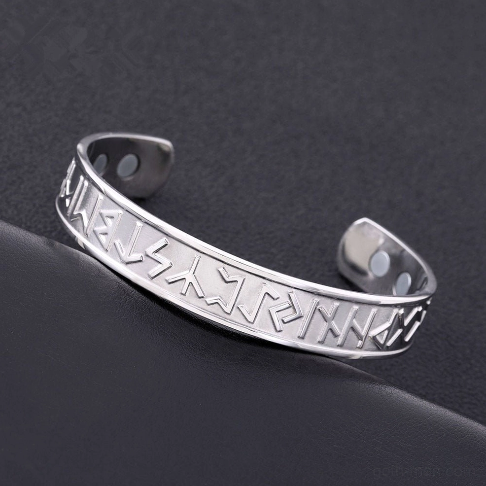 Silver stainless steel Nordic rune open cuff bracelet styled on dark leather background, gothic aesthetic display