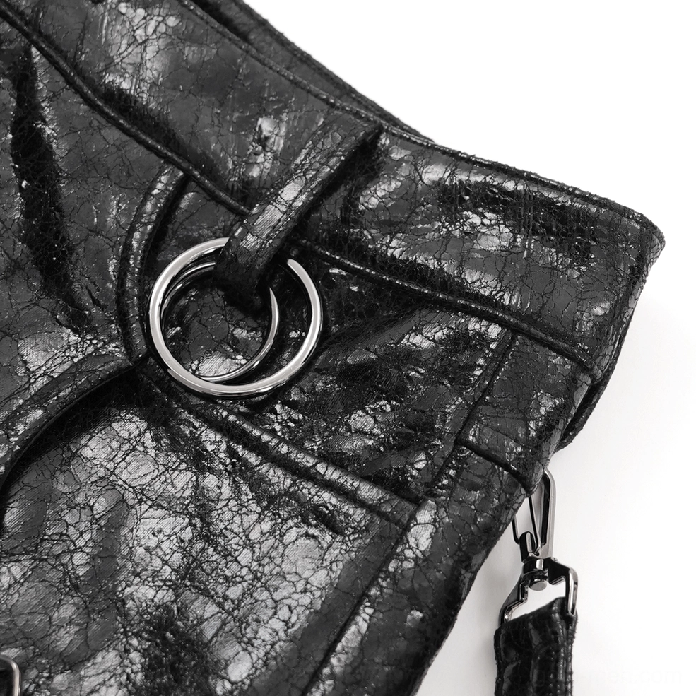 Macro photography of silver double O-rings with leather strap and metal clasp hardware