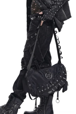 Close-up detail of metal hardware and spiked studs on black gothic crossbody bag, showing industrial craftsmanship