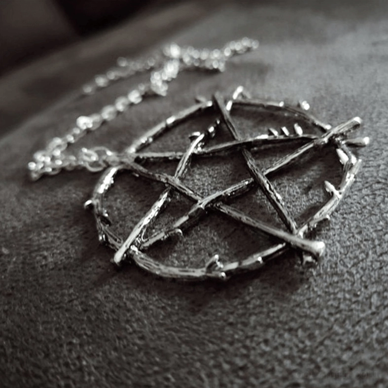 Side overhead close-up of twig textured pentagram pendant, revealing intricate thorn-like details and aged dark metal finish of occult amulet